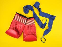 pair of red leather boxing gloves and blue textile bandage photo