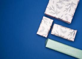 gifts wrapped in colored paper on a blue background photo