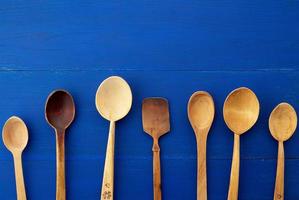 set of yellow wooden vintage spoons on a blue wooden background photo