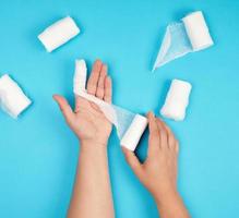 process of rewinding the index finger to the hand with a white sterile medical bandage photo