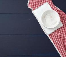 rectangular white cutting kitchen board and empty round plate on a blue wooden background, photo