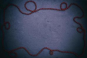 black background with red Christmas garland of small balls photo