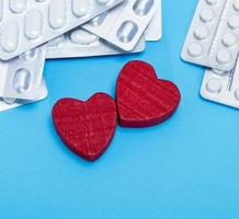 different pills in a package and two red hearts photo