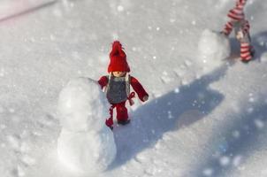 Two wooden dolls on white snow photo