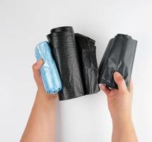 plastic garbage bags  in female hands on a white background photo