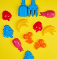 juguetes de plástico multicolor frutas sobre un fondo amarillo foto