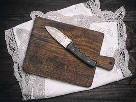 old brown wooden cutting board with handle and knife photo