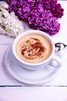 Cup of cappuccino on a white wooden table photo