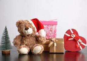 brown teddy bear and a stack of various cardboard boxes for gifts photo