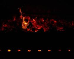 quemando troncos de madera en el fuego por la noche foto
