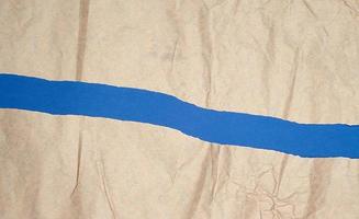 hoja de papel marrón rota sobre un fondo azul, marco completo foto