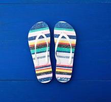 Flip flop in flat style on blue wooden background