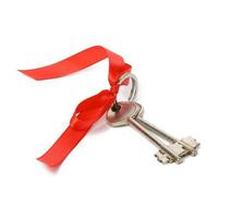 two metal house door keys with red ribbon isolated on white background photo