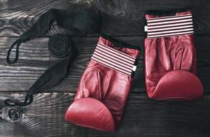 guantes de boxeo de cuero rojo y una venda elástica negra foto