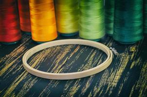 wooden hoop closeup on a background of colorful spools of thread photo