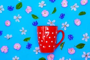 ceramic red mug  with white polka dots on a blue background photo