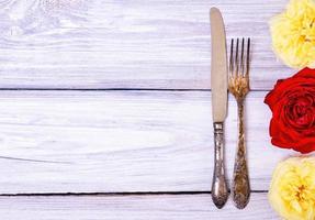 Iron cutlery fork and knife on a white wooden table photo