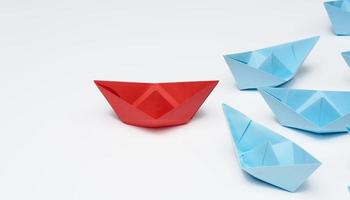 group of paper boats on a white background. concept of a strong leader in a team, manipulation of the masses, following new perspectives, collaboration and unification. Startup photo