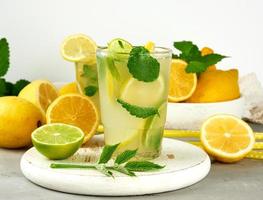 summer refreshing drink lemonade with lemons, mint leaves, lime in a glass photo