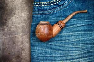 smoking wooden pipe on blue dzhinskah worn photo