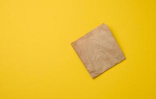 Brown paper craft bag for food packaging on a yellow background photo