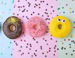 round donuts with various fillings and sprinkles on an abstract color background photo