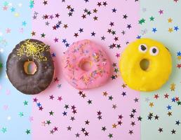 round donuts with various fillings and sprinkles on an abstract color background photo