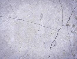 Fragment of a gray cement wall with cracks photo