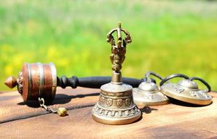 campana de cobre con objetos religiosos tibetanos, de cerca foto