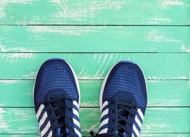 zapatillas deportivas azules sobre fondo de madera verde foto