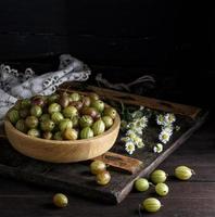 wooden bowl with green gooseberries photo