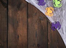 multicolored felt spider figures on brown wooden background photo