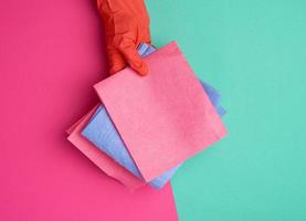 blue viscose rag for cleaning dust in the house in hands with an orange glove photo