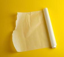 unwound white parchment baking paper on a yellow background photo