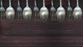 Wooden background with vintage spoons and forks photo