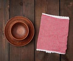 empty brown ceramic plates on a wooden table photo