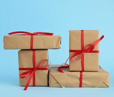 stack of boxes wrapped in brown paper and tied with a red bow photo