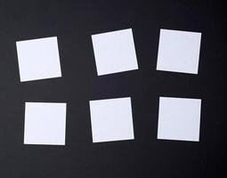 empty white small square sheets of paper on a black background photo