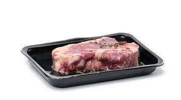 Raw New York beef steak is packed in a plastic container and vacuum sealed. Long-term storage striploin meat photo