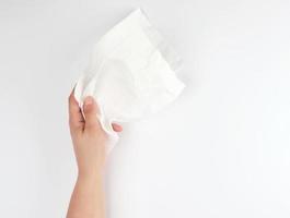 female hand holding a clean white paper napkin photo