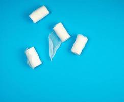 rolled up white sterile medical bandages on a blue background photo