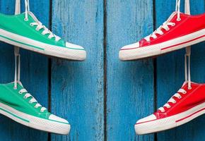 textile sports shoes hanging on a blue wall photo