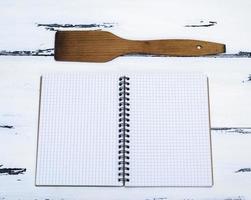 open empty notebook in a box and a kitchen spatula photo