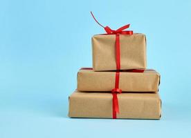 stack of boxes wrapped in brown paper and tied with a red bow photo