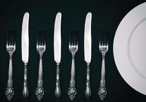 Half empty white plates, vintage knife and fork on  table photo