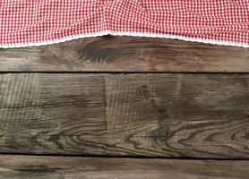 red-white textile kitchen towel on a wooden background from old gray boards photo