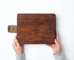 female hands holding an old empty wooden rectangular cutting board photo