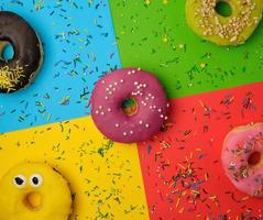 round donuts with various fillings and sprinkles on an abstract color background photo