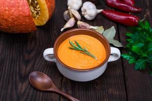 cream soup of fresh pumpkin in a ceramic plate photo