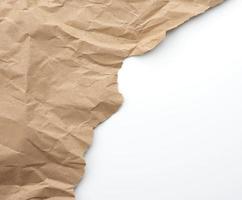 fragment of crumpled blank sheet of brown wrapping kraft paper with torn edges photo